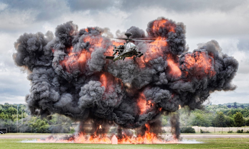 Illustration for article titled Here's an Apache attack helicopter flying away from a monster explosion